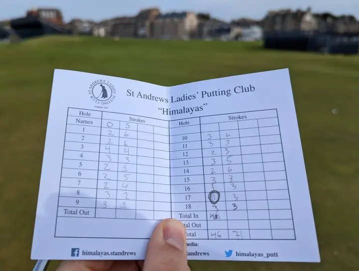 A physical golf scorecard with handwritten scores